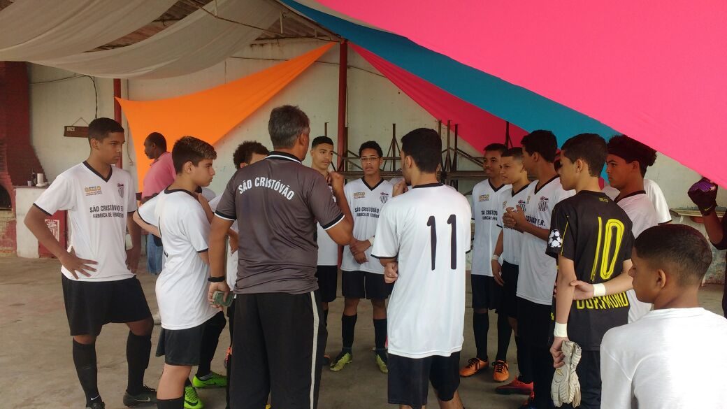 Turma da Escolinha do Tio Alexandre reunida com o professor no campo antes do treino